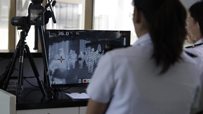 Airport personnel look at thermal scanners as they check on arriving passengers at Manilas international airport, Philippines, Thursday, Jan. 23, 2020. The government is closely monitoring arrival of passengers as a new coronavirus outbreak in Wuhan, China has infected hundreds and caused deaths in that area. (AP Photo/Aaron Favila)
