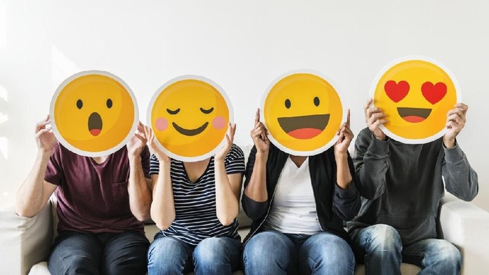 Diverse people holding emoticon