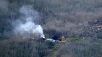 Puing-puing helikopter tampak berserakan di lokasi kejadian. AP Photo/Richard Vogel.