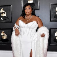 Lizzo tampil bak ratu salju dalam balutan gaun putih Versace yang dilengkapi syal bulu-bulu. (Foto: Amy Sussman/Getty Images)