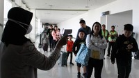 Petugas melakukan pendeteksi suhu tubuh (thermal scanner) saat penumpang pesawat tiba di terminal 2 Bandara Juanda Surabaya, Jawa Timur, Rabu (22/1/2020). ANTARA FOTO/Umarul Faruq.