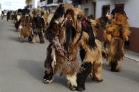 Para pria mengenakan kostum ala Chewbacca 'Star Wars' sambil berjalan di sekitar rumah-rumah penduduk.