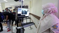 Petugas (kanan) Kantor Kesehatan Pelabuhan (KKP) bandara Sultan Iskandar Muda (SIM) mengamati para penumpang yang baru tiba dari Malaysia dengan alat deteksi suhu tubuh (thermoscan) di terminal kedatangan bandara Internasional SIM, Aceh Besar, Aceh, Senin (27/1/2020). ANTARA FOTO/Irwansyah Putra.