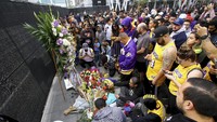 Para penggemar Kobe Bryant berkumpul di Staples Center, Los Angeles. Mereka datang dengan membawa karangan bunga duka cita. AP Photo/Matt Hartman.