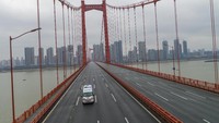 Sebuah mobil ambulans melintas di salah satu jalan yang tampak sepi di kawasan Wuhan, China, usai wilayah itu terisolasi untuk mengantisipasi penyeberan virus corona jenis baru yang makin meluas. Chinatopix via AP.