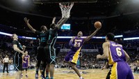 Kobe Bryant yang mendapat pengawalan ketat dua pemain Charlotte Hornets melompat untuk memasukkan bola. Jonathan Daniel/Getty Images.