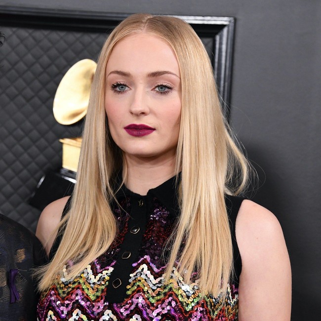 Mendukung sang suami Joe Jonas, Sophie Turner tampil dengan lipstik bold warna plum. Untuk mata, menggunakan eyeshadow nuansa pink dengan maskara tebal di atas dan bawah mata.  Foto: Getty Images