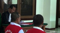 Terdakwa mendengarkan pembacaan dakwaan oleh jaksa.