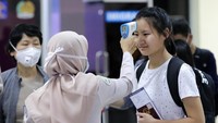 Pengamatan dan pemeriksaan menggunakan alat pendeteksian suhu tubuh terhadap para penumpang pesawat luar negeri di terminal kedatangan jalur internasional guna mengantisipasi penyebaran Virus Corona. ANTARA FOTO/Irwansyah Putra.