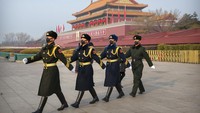 Sejumlah penjaga beraktivitas di kawasan Lapangan Tiananmen dengan menggunakan masker pelindung pernapasan.
