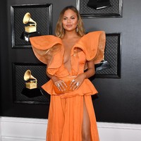 Chrissy Teigen tak suka bermain aman ketika menghadiri ajang sekelas Grammy Awards. Tahun ini, istri John Legend itu memakai gaun oranya Yanina Couture yang hadir dengan belahan tinggi pada rok dan belahan di area dada. (Foto: Amy Sussman/Getty Images)