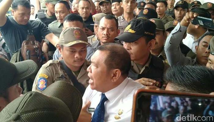 Rusdi Sinuraya (baju putih) saat ditarik petugas Satpol PP Medan (Ahmad Arfah Fansuri/detikcom)