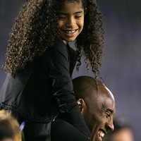 Gigi duduk di bahu ayahnya saat menghadiri laga persahabatan antara tim Amerika Serikat dan China di Qualcomm Stadium, San Diego, California, AS, pada 2014. Keduanya tampak bahagia kala itu. (Foto Kent C. Horner/Getty Images)