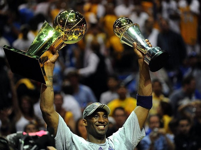 ORLANDO, FL - JUNE 14:  Kobe Bryant #24 of the Los Angeles Lakers holds up the Larry OBrien trophy and the Bill Russell MVP trophy after the Lakers defeated the Orlando Magic 99-86 in Game Five of the 2009 NBA Finals on June 14, 2009 at Amway Arena in Orlando, Florida.  NOTE TO USER:  User expressly acknowledges and agrees that, by downloading and or using this photograph, User is consenting to the terms and conditions of the Getty Images License Agreement.  (Photo by Ronald Martinez/Getty Images)