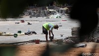 Tidak hanya pekerja, mobil truk pengangkut pasir dan tanah juga masih terlihat lalu lalang di dalam lokasi. Selain itu, alat berat seperti beko juga tampak aktif mengeruk tanah.