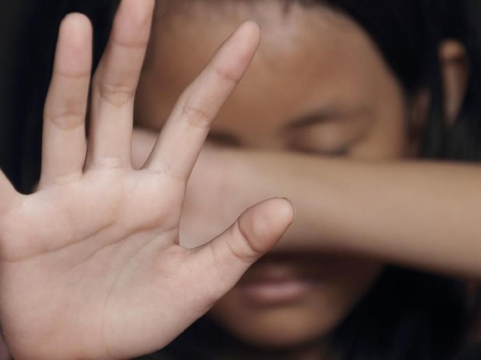 Little girl suffering bullying raises her palm asking to stop the violence