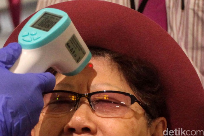 Bandara Soetta Perketat Turis China Akibat Virus Corona Seorang petugas tengah memeriksa warga yang baru tiba di Bandara Soekarno Hatta, Tangerang, Senin (27/1/2020). Hal tersebut guna mencegah masuknya virus corona yang tengah marak diberitakan.