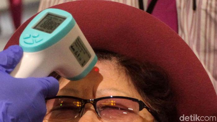 Bandara Soetta Perketat Turis China Akibat Virus Corona Seorang petugas tengah memeriksa warga yang baru tiba di Bandara Soekarno Hatta, Tangerang, Senin (27/1/2020). Hal tersebut guna mencegah masuknya virus corona yang tengah marak diberitakan.