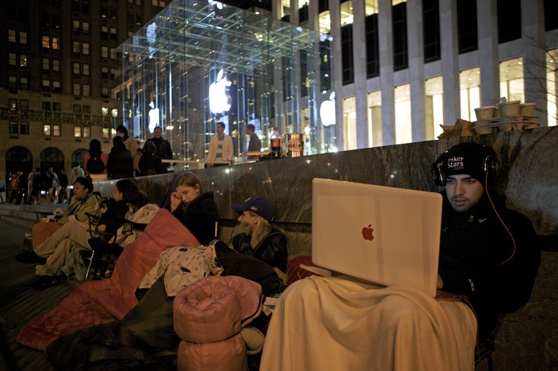 NEW YORK - APRIL 2:  Sinai Azmoudea, 23, of Dallas Texas, right, waits on line for the release of Apple's iPad on April 2, 2010 at the Apple Store on Fifth Avenue in New York City. Employees set up barriers to control the throngs expected to line up for the $499 device which goes on sale Saturday. (Photo by David Goldman/Getty Images)