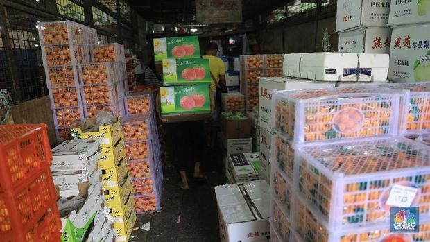 Suasana aktifitas pasar induk Kramat Jati di Blok buah, Jakarta Timur, Selasa (28/1/2020). Kementerian Pertanian  memperketat pintu masuk impor beberapa jenis makanan termasuk buah-buahan dari daerah atau negara tertentu yang kemungkinan terkontaminasi virus corona sebagai upaya pencegahan penyebaran virus tersebut. Upaya pengetatan dilakukan melalui penerapan biosecurity terhadap komoditas impor untuk mencegah penyebaran Virus Corona. Sampai saat ini, ia memastikan belum ada data yang menunjukkan kontaminasi Virus Corona terhadap komoditas impor. Pantauan CNBC dilokasi pasar pedagang pasar mengaku dagangannya normal biasa saja. Hanya saja pasoka  importir buah belum datang dan rencana april nanti. Puji salah satu pedagang mengatakan 