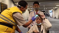 Penumpang yang baru tiba diperiksa suhu tubuhnya oleh petugas kesehatan Bandara Soekarno-Hatta.