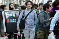 TOKYO - MAY 28:  Ken Sekine (L) in an iPad costume waits in a queue for Apple Inc.s iPad tablet computers outside the Apple Store Ginza on the day of its Japanese launch on May 28, 2010 in Tokyo, Japan. The iPad, which has already sold over 1 million units in the U.S. since its release, is available in both the Wi-Fi and the Wi-Fi + 3G models in Australia, Canada, France, Germany, Italy, Japan, Spain, Switzerland and the UK with its international launches.  (Photo by Kiyoshi Ota/Getty Images)