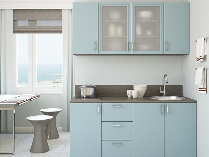 Scandinavian style kitchen with geometric backsplash and blue and white cupboards