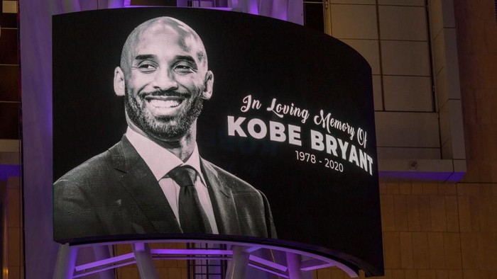 LOS ANGELES, CA - JANUARY 26: Memorial signage hangs near people mourning for former NBA star Kobe Bryant, who was killed in a helicopter crash in Calabasas, California, near Staples Center on January 26, 2020 in Los Angeles, California. Nine people have been confirmed dead in the crash, among them Bryant and his 13-year-old daughter Gianna. (Photo by David McNew/Getty Images)