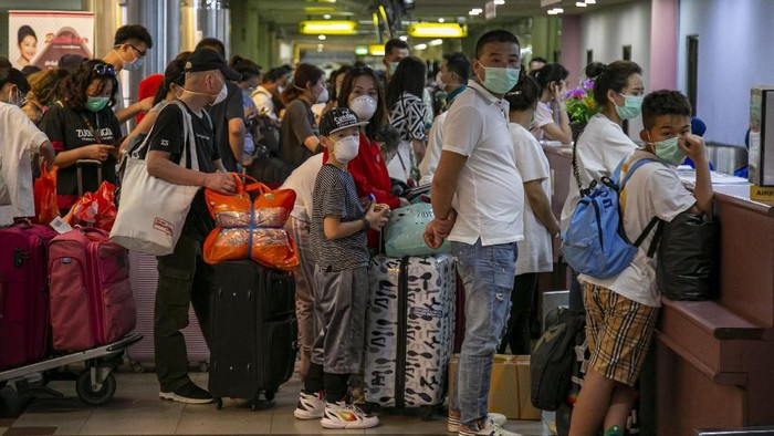 Sejumlah wisatawan asing asal China antre di konter lapor diri (check-in) Terminal Keberangkatan Bandara Hang Nadim, Batam, Kepulauan Riau, Selasa (28/1/2020). Agen biro perjalanan China memulangkan ratusan wisatawannya yang sedang berkunjung di Batam menyusul merebaknya wabah virus Korona, selain itu pihak Bandara Hang Nadim juga menghentikan sementara penerbangan dari China ke Batam sampai batas waktu yang belum ditentukan. ANTARA FOTO/M N Kanwa/wsj.