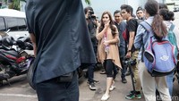 Ayu tampak menerobos kerumunan wartawan yang menantinya. Pool/Palevi S/detikFoto.