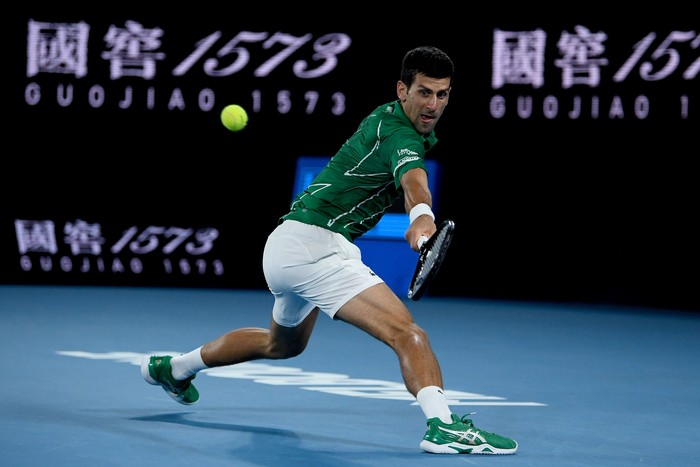 MELBOURNE, AUSTRALIA - JANUARY 28: Novak Djokovic of Serbia plays a backhand during his Menâ€™s Singles Quarterfinal match against Milos Raonic of Canada on day nine of the 2020 Australian Open at Melbourne Park on January 28, 2020 in Melbourne, Australia. (Photo by Hannah Peters/Getty Images)