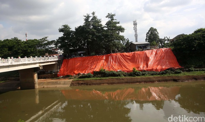 Terpal menutup lahan yang longsor di Banjir Kanal Timur, Malaka Sari, Jakarta Timur, Selasa (28/1/2020). Hal ini untuk mencegah longsor susulan.
