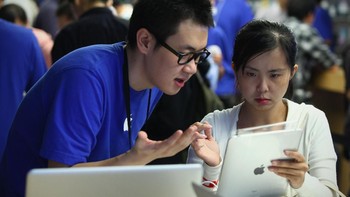 Staf Apple Store menerangkan fitur-fitur iPad ke konsumen. Foto: Feng Li/Getty Images