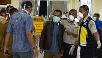 Petugas Kantor Kesehatan Pelabuhan (KKP) memasangkan masker dilanjutkan pemeriksaan kesehatan terhadap mahasiswa asal Aceh, Muhammad Sahuddin (ketiga kanan) seusai perjalanan dari China di Bandara Internasional Sultan Iskandar Muda, Aceh Besar, Aceh, Selasa (28/1/2020).