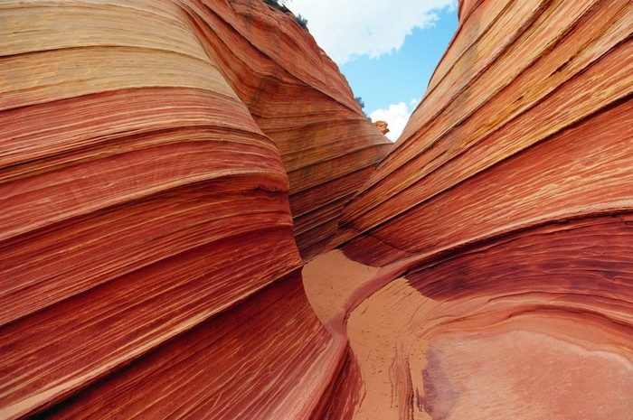 Slot canyon wave pattern with sky reflected in water