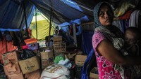 Seorang ibu menggendong anaknya di depan tenda pengungsian di Kampung Susukan, Lebak, Banten, Selasa (28/1/2020).