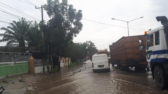 Jalan lintas Sumatera di Tanjung Morawa arah Medan tergenang air usai hujan deras mengguyur sejak kemarin malam hingga dini hari tadi. Arus lalu lintas tersendat di titik yang terendam air.