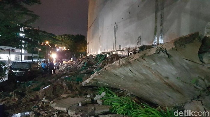 Tembok pembatas proyek apartemen roboh.