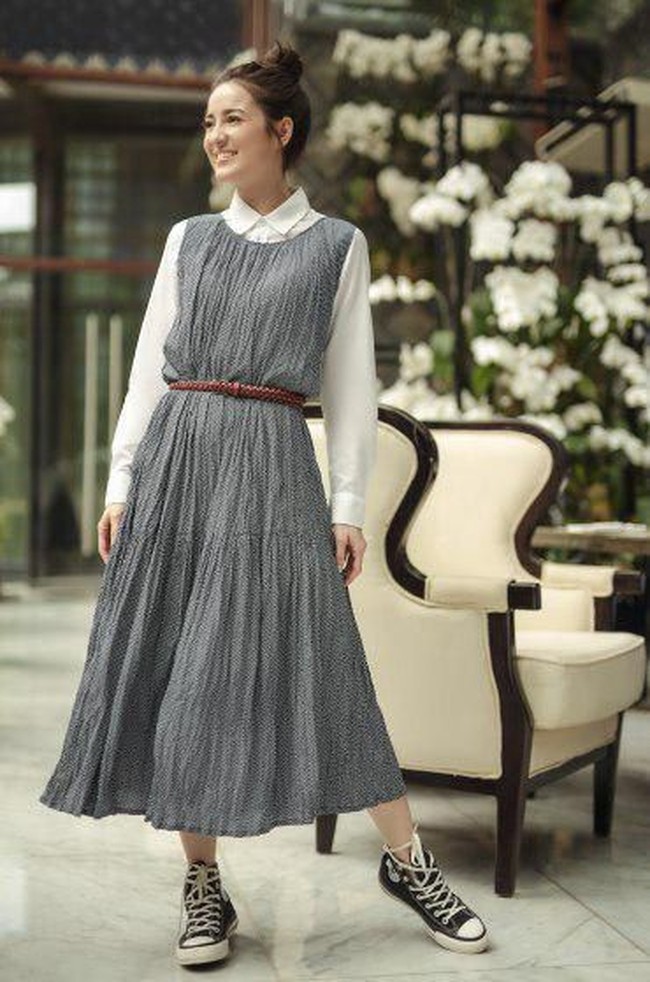 Julie Estelle memadupadankan dua koleksi Uniqlo x Ines de la Fressange pada look pertamanya bergaya Parisian Chic. Dress pleated tanpa lengan dibuat menjadi formal dan tetap stylish dengan padanan kemeja putih lengan panjang berkerah dan belt. Foto: dok. Uniqlo