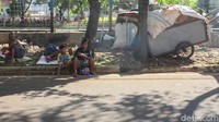 Sejumlah pemulung tampak beristirahat di pinggir jalan.