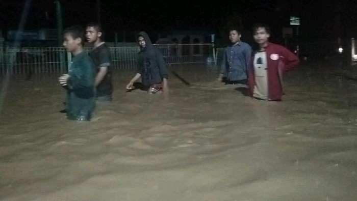 Warga mengungsi melewati banjir yang melanda Kecamatan Barus, Kabupaten Tapanuli Tengah