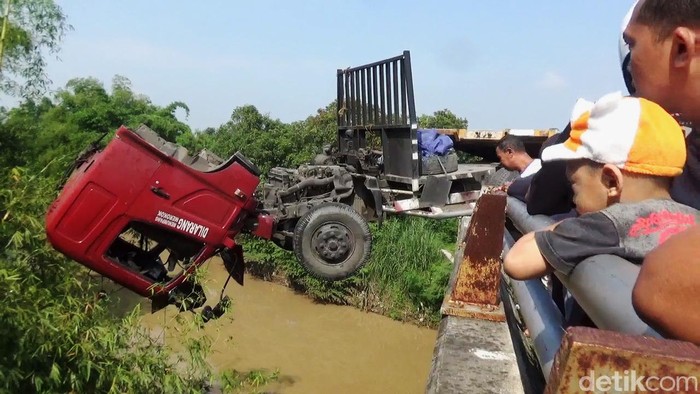 Truk Menggantung di Jembatan Akibat Sopir Ngantuk Kecelakaan tunggal terjadi di ring road atau jalan lingkar Mojoagung, Jombang. Sebuah truk trailer menabrak jembatan Sungai Gunting karena sopir mengantuk, Rabu (29/1/2020). Akibatnya, sopir dan kernet truk tercebur ke sungai dari ketinggian sekitar 10 meter. Sementara posisi truk juga menggantung di jembatan.