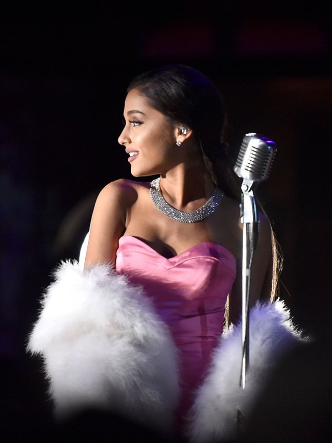 Ariana Grande memadukan kalung dengan total berlian 65 karat ini dengan gaun strapless pink dan syal berbulu. Penampilannya terlihat glamor dan feminin. Foto: Getty Images