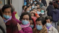 Dengan mengenakan masker, warga mengantre di depan apotek di kawasan Hong Kong untuk membeli masker pelindung pernapasan. AP Photo/Kin Cheung.