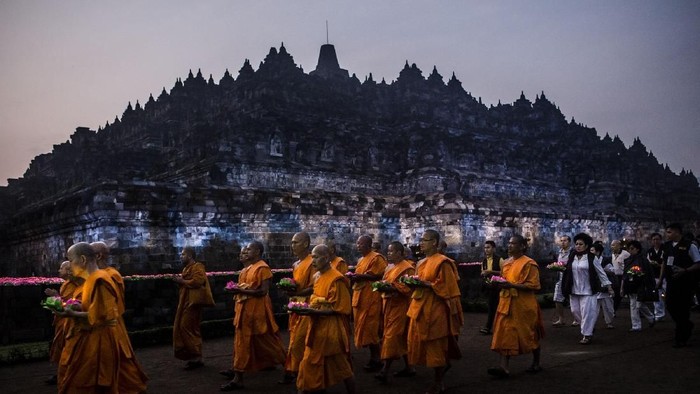 MAGELANG, CENTRAL JAVA, INDONESIA - MAY 10: Tourists at Borobudur temple during celebrations for Vesak Day on May 10, 2017 in Magelang, Central Java, Indonesia. Buddhists in Indonesia celebrate Vesak at the Borobudur temple annually, which makes it the most visited tourist attraction in Indonesia. It is observed during the full moon in May or June, with the ceremony centered at three Buddhist temples by walking from Mendut to Pawon and ending at Borobudur. The stages of life of Buddhisms founder, Gautama Buddha, which are celebrated at Vesak are his birth, enlightenment to Nirvana, and his passing (Parinirvana). (Photo by Ulet Ifansasti/Getty Images)