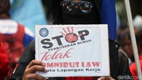 Seorang demonstran membawa poster bertuliskan Stop Perbudakan Buruh Tolak Omnibus Law Cipta Lapangan Kerja saat ikut serta dalam aksi demo di kawasan Istana Negara, Jakarta.