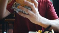 Pose candid dan terlihat tampan itu juga ditunjukkan ketika menyantap burger dan kentang goreng ini. Mr Dennis kok ganteng banget sih, komentar salah satu netizen. Foto: Instagram @gurukumrd