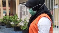 VA nampak mengenakan hijab berwarna hitam dan masker saat hendak masuk ke ruang sidang.