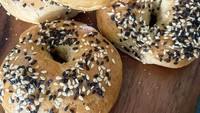 Bentuk bagel selintas mirip donat, namun dua makanan ini berbeda. Bagel dibuat dari tepung terigu dan ragi sebagai bahan utamanya. Di atasnya umum diberi bijian seperti wijen hitam dan putih yang menambah tekstur renyah. Foto: Instagram ffold