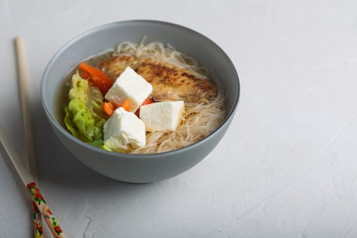 Traditional spicy asian soup with tofu cheese and noodles. This dish usually contains bouillon and vegetables